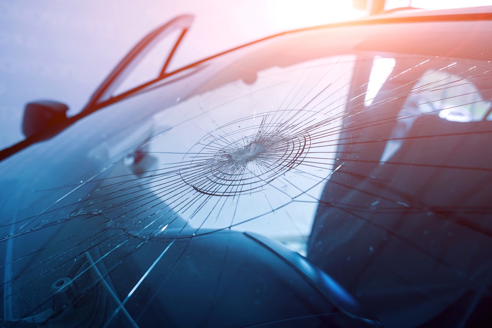 Closeup of a car windshield with a single, focused circular impact, representing special damages in personal injury cases.