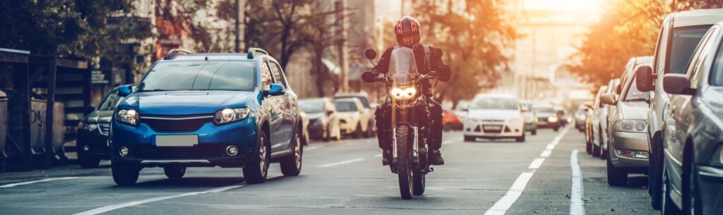 speeding motorcycle in traffic, on a road, through a crosswalk