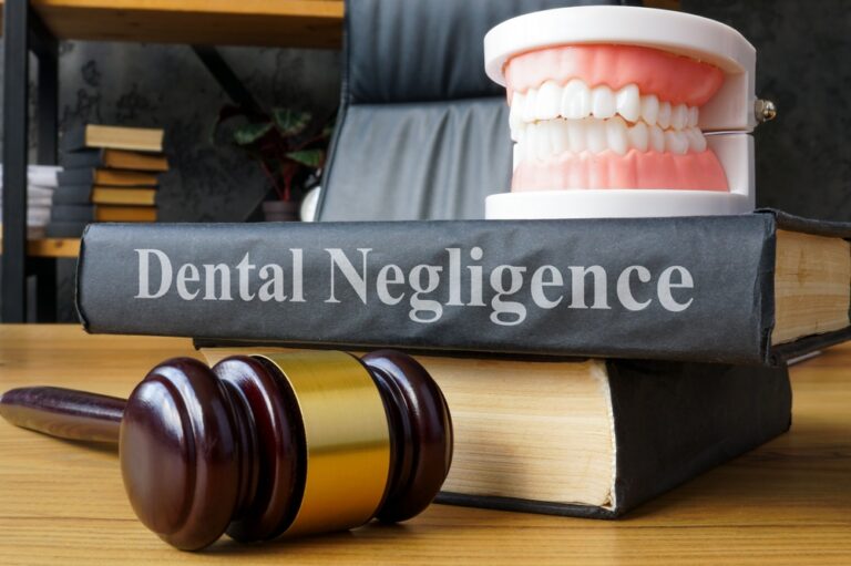 image showing a dental negligence inscripted book, dentures and a law gavel
